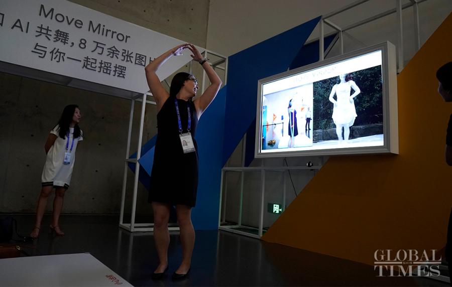 Visitors test out an AI software that matches poses to photos.  (Photo: Yang Hui/GT)