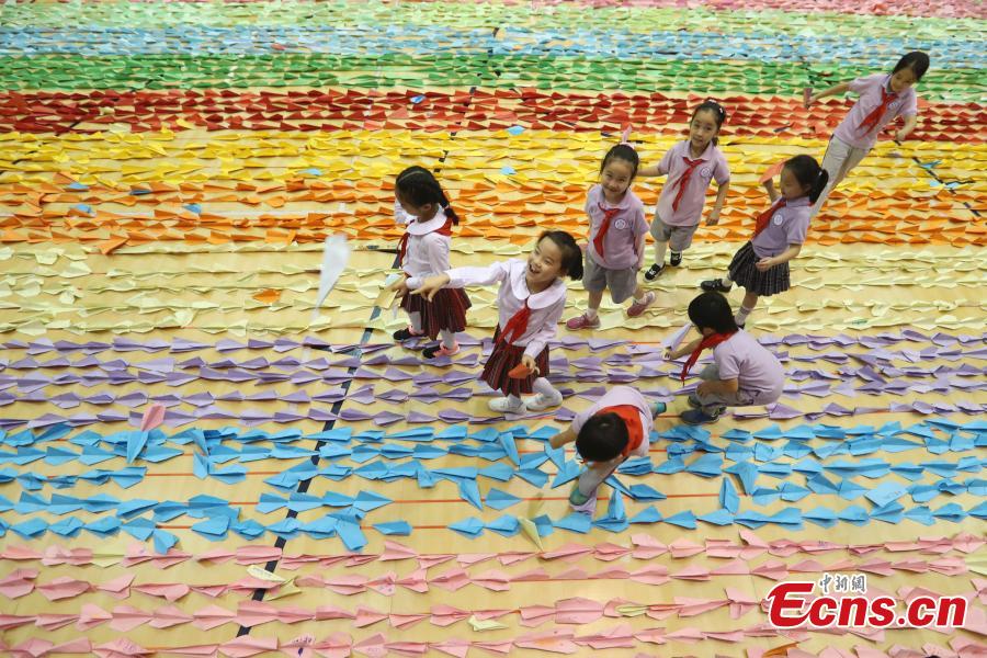 Primary school students fly paper aircrafts during an attempt to set a world record in Beijing, Sept. 20, 2018. Children from 22 provinces and cities made more than 60,000 paper planes, of which 14,285 were selected to create a line measuring 3,029.02 meters in length. It\'s the world\'s longest line of paper aircrafts and set a new Guinness World Record. The project was initiated by the China Children and Teenagers\' Fund and the Sister Ma Food Company in May. (Photo: China News Service/Sheng Jiapeng)