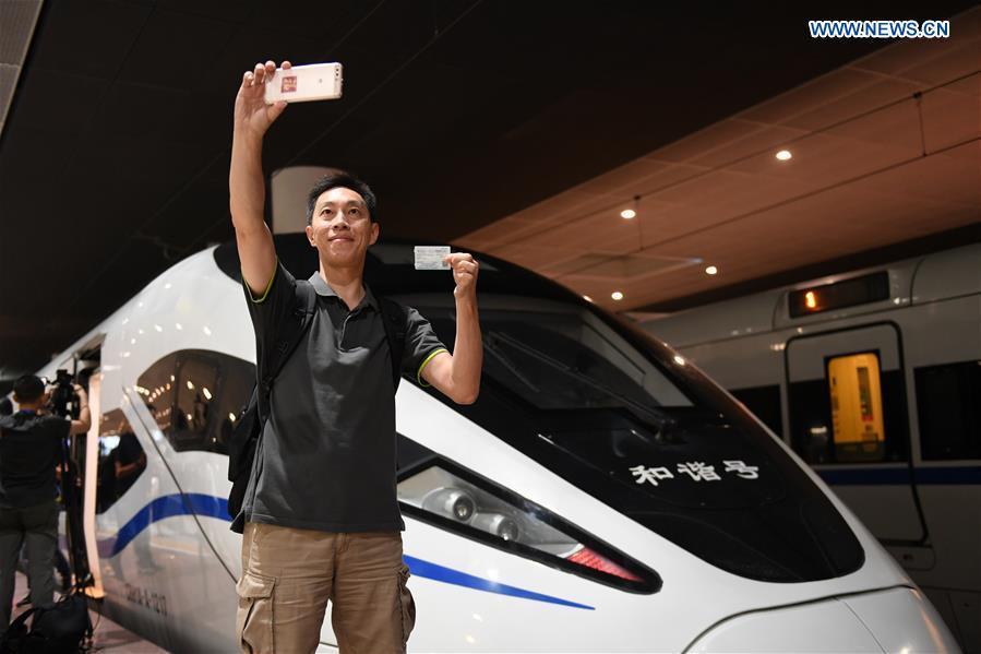 A passenger takes a selfie with G5711, the first high-speed train from Shenzhen to Hong Kong, at Shenzhen North Railway Station in Shenzhen City, south China\'s Guangdong Province, Sept. 23, 2018. G5711 train left Shenzhen North Railway Station at 6:44 Beijing Time on Sunday (1044 GMT Saturday) for West Kowloon Station in Hong Kong, marking the opening of the Hong Kong section of the Guangzhou-Shenzhen-Hong Kong High-speed Railway and that of the whole Guangzhou-Shenzhen-Hong Kong High-speed Railway. (Xinhua/Mao Siqian)
The whole line of the Guangzhou-Shenzhen-Hong Kong Express Rail Link is fully open to traffic, as high-speed train G5736 left Hong Kong West Kowloon Station at 7 a.m. Sunday to head for Shenzhen North Railway Station in Guangdong Province on the mainland.
On the mainland, at 6:44 a.m., high-speed train G5711 left Shenzhen North Railway Station to head for Hong Kong West Kowloon Station.