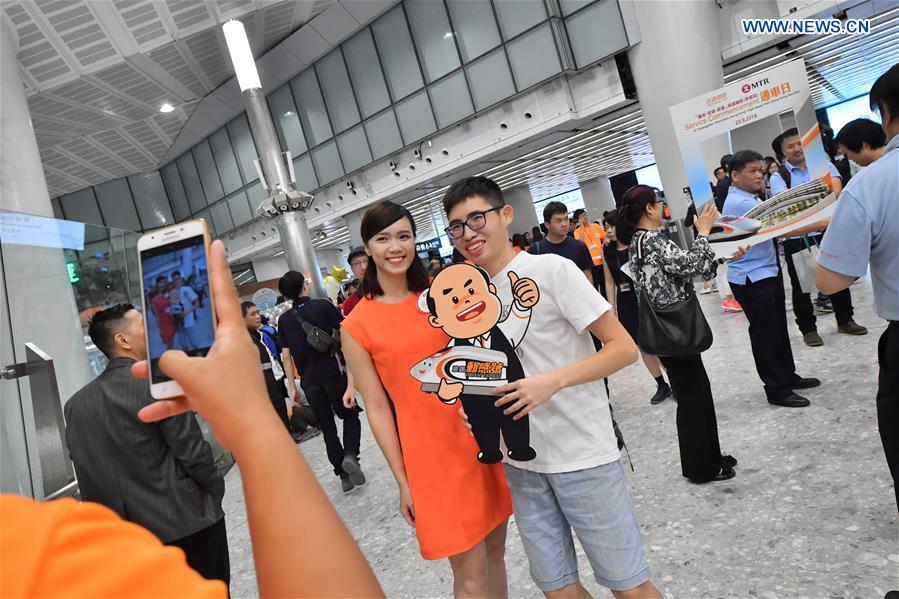 Passengers pose for photos at West Kowloon Station in Hong Kong, south China, Sept. 23, 2018. Train G5736 left Hong Kong West Kowloon Station at 7:00 on Sunday (1100 GMT Saturday) for Shenzhen North Railway Station. At 6:44, train G5711 left Shenzhen North Railway Station for Hong Kong West Kowloon Station, marking the opening of the Hong Kong section of the Guangzhou-Shenzhen-Hong Kong High-speed Railway and that of the whole Guangzhou-Shenzhen-Hong Kong High-speed Railway. (Xinhua/Lui Siu Wai)