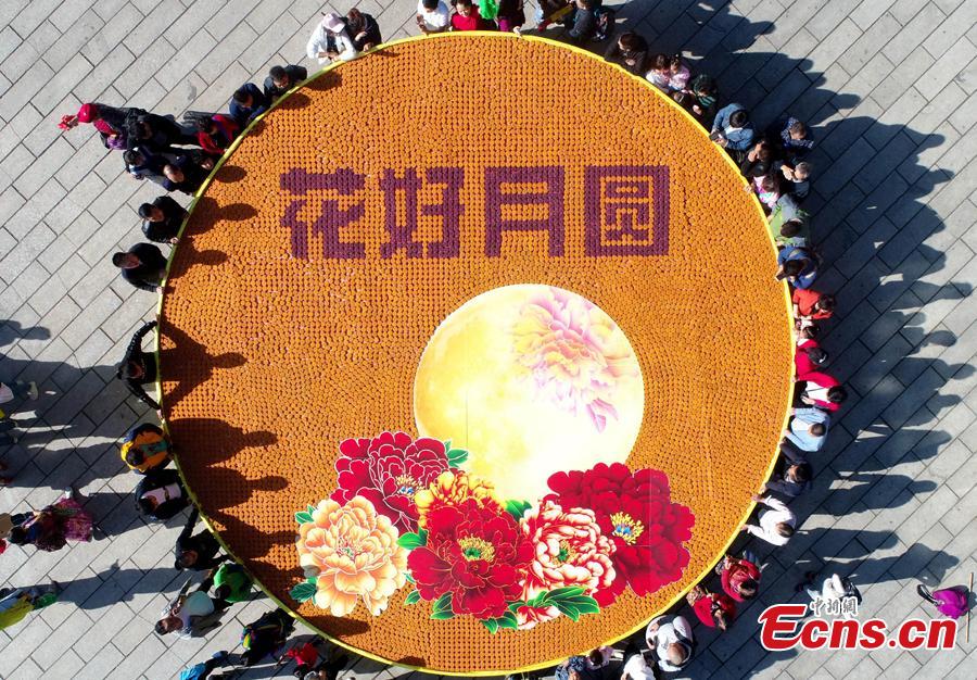 <?php echo strip_tags(addslashes(Staff members at Laojun Mountain, a scenic spot in Luoyang City, Central China's Henan Province, use 9,999 colorful mooncakes to spell out a beautiful pattern with Chinese characters of Hua Hao Yue Yuan (Blooming flowers and full moon) to celebrate the Mid-Autumn Festival, Sept. 23, 2018. (Photo: China News Service/Wang Zhongju))) ?>