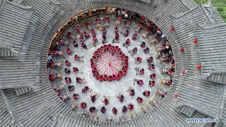 In this aerial photo taken on Sept. 23, 2018, women of the Yao ethnic group demonstrate the making of folk costumes in Xiaozhai Village of Longji Township in Guilin, south China\'s Guangxi Zhuang Autonomous Region. People across China hold various activities to celebrate the country\'s first Farmers\' Harvest Festival, which falls on Sept. 23 this year. (Xinhua/Pan Zhixiang)