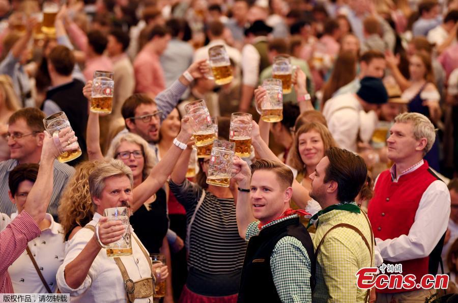 Visitors cheer with beers during the 185th Oktoberfest in Munich, Germany. Thousands of visitors, many of them dressed in traditional lederhosen or dirndl corseted dresses, descended on Munich on Saturday for the start of the annual Oktoberfest, the world’s largest beer festival. Oktoberfest is the world\'s largest beer celebration and typically draws over six million visitors over its three-week run. Oktoberfest includes massive beer tents, each run by a different Bavarian brewer, as well as amusement rides and activities.  (Photo/Agencies)