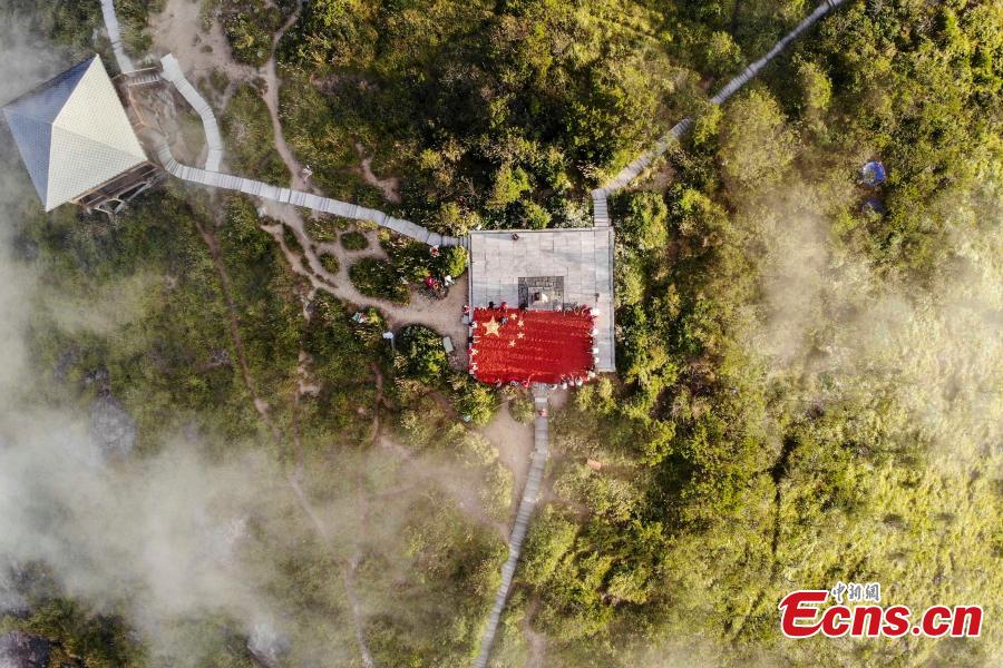 <?php echo strip_tags(addslashes(Farmers use eight tons of freshly-harvested peppers and corn to create a giant national flag on the top of Longquan Mountain in Zhejiang Province, Sept. 26, 2018, as part of harvest celebrations. The flag measured 10 meters in length and was 6.6 meters wide. The mountain is the highest peak in the Yangtze River Delta. (Photo: China News Service/Yang Yong))) ?>