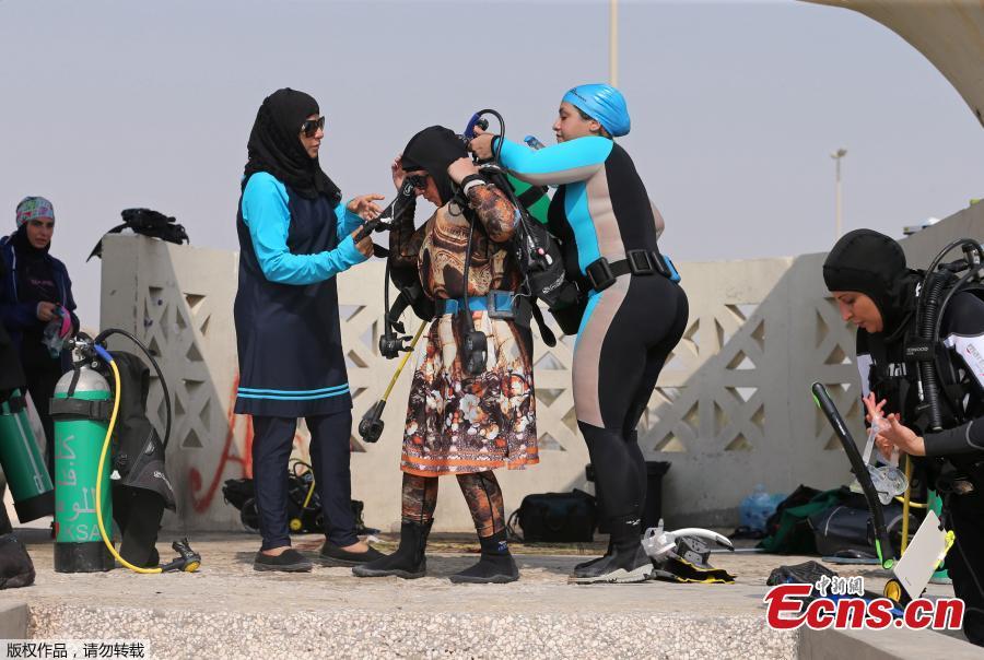 Bothaina Al Yousef (L) and Dana Al Qatari (R) help their fellow diver Zynab Al Magaslah (C) to wear her diving equipment as they get ready to dive at Half Moon Beach open-water dive site in Dhahran, Saudi Arabia, Sept. 15, 2018. (Photo/Agencies)