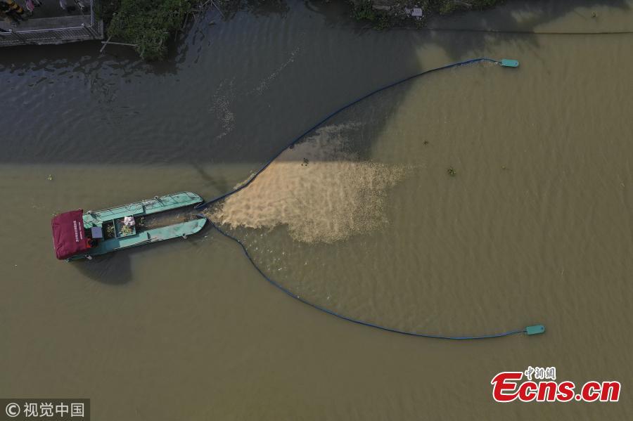 A boat equipped with a new device collects garbage in a river in Pingyang County, East China’s Zhejiang Province, Sept. 25, 2018. The rope-like electronic devices can be remotely controlled to rise above or fall under the water to collect floating garbage. (Photo/VCG)
