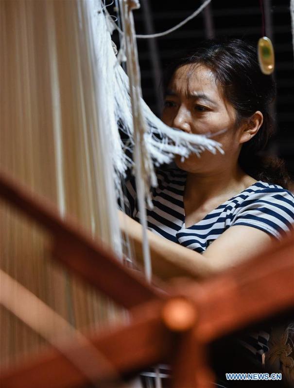 A weaver knits Yun brocade at the Nanjing Yunjin Museum in Nanjing, capital of east China\'s Jiangsu Province, Sept. 26, 2018. Yunjin, also called Yun brocade, is traditional Chinese silk brocade made in Nanjing of Jiangsu. Dated from the Eastern Jin Dynasty, it has formed its own characteristics through its development of 1,600 years. Yun brocade is famous for its exquisite craft, elegant patterns and smooth texture, and the making of the artwork requires close cooperation of two weavers, who can produce only five centimeters a day. In 2009, Yun brocade was inscribed on the Representative List of the Intangible Cultural Heritage of Humanity. (Xinhua/Li Xiang)