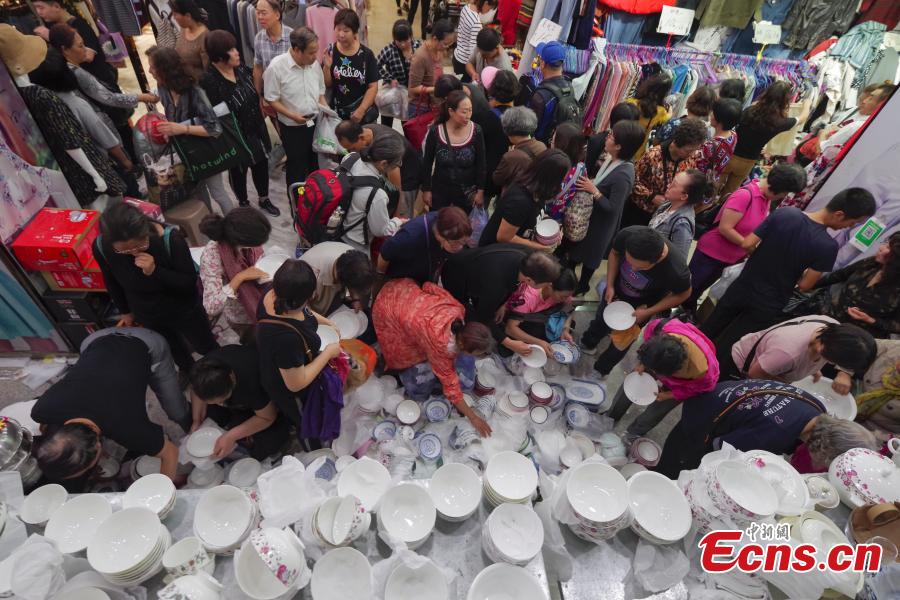 Customers purchase goods during a clearance sale at the Guanyuan Wholesale Market in Xicheng District, Beijing, Sept. 28, 2018. The market, opened in 1998, was shut down permanently on Friday as the capital continues efforts to remove non-capital functions and solve \