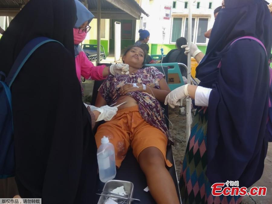 A handout photo made available by the Indonesian National Board for Disaster Management (BNPB) shows a resident receiving medical treatment after an earthquake that hit in Donggala, Central Sulawesi, Indonesia, Sept. 28, 2018. A tsunami caused deaths when it hit a small city on the Indonesian island of Sulawesi on Friday after a major quake, collapsing buildings and cutting off power, officials said, although the exact number of casualties was not clear.(Photo/Agencies)