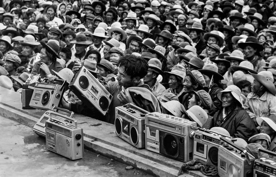 Radio cassette recorders－fashionable gadgets at the time－are placed on a stage to record the ongoing Epic of King Gesar performance during a horse race in Nagqu, in the Tibet autonomous region, in 1983. [TASHI TSEDAN/FOR CHINA DAILY]