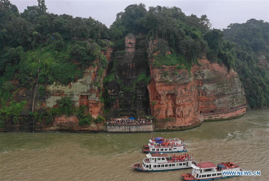 People view the statue of the Leshan Giant Buddha in Leshan City, southwest China\'s Sichuan Province, Oct. 4, 2018. The Leshan Buddha scenic area received about 43,800 visitors on the fourth day of China\'s National Day holiday. (Xinhua/Jiang Hongjing)