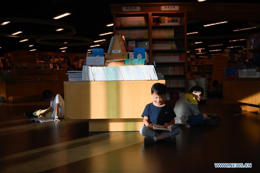 Children read books at a bookstore during the week-long National Day holiday in Hangzhou, capital of east China\'s Zhejiang Province, Oct. 5, 2018. (Xinhua/Huang Zongzhi)