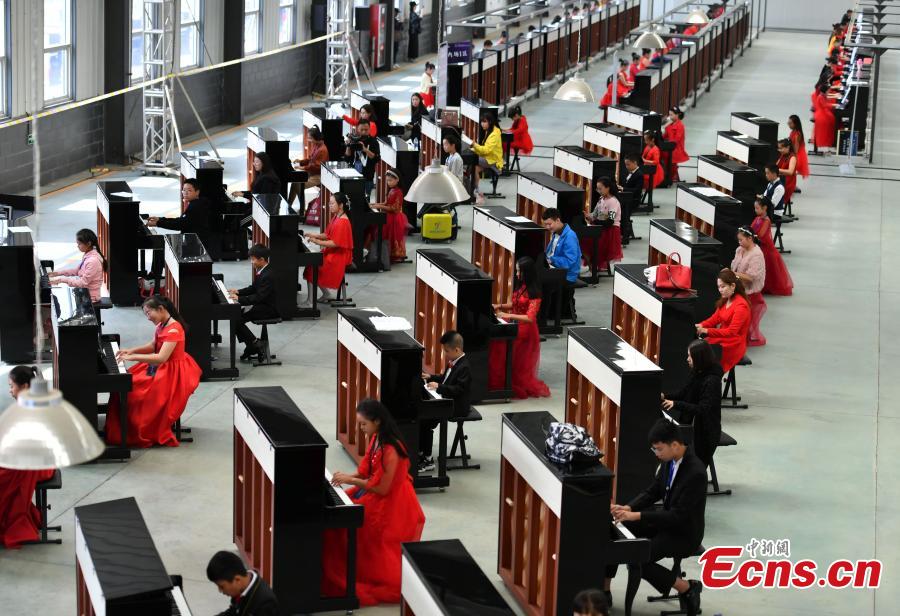 Participants play pianos at the same time in an attempt to set a Guinness World Record for the most pianos played simultaneously at the R?NISCH industry park in Wuqiang County, North China’s Hebei Province, Oct. 6, 2018. A total of 666 pianos were played in the challenge. (Photo: China News Service/Zhai Yujia)
