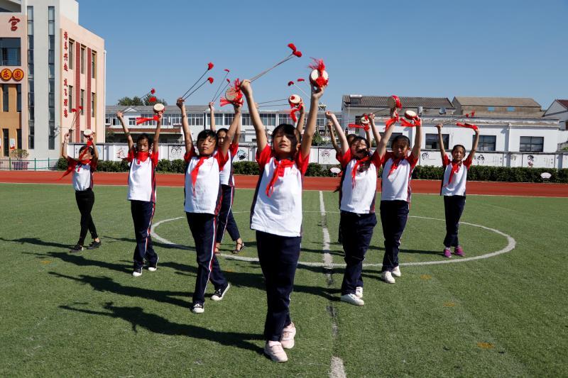 A group of primary school students perform the Fengyang Flower-drum Dance during a break between classes on Sept. 27. Popular in Fengyang county, which governs Xiaogang village, the dance has a history of more than 600 years. (Photo/chinadaily.com.cn)