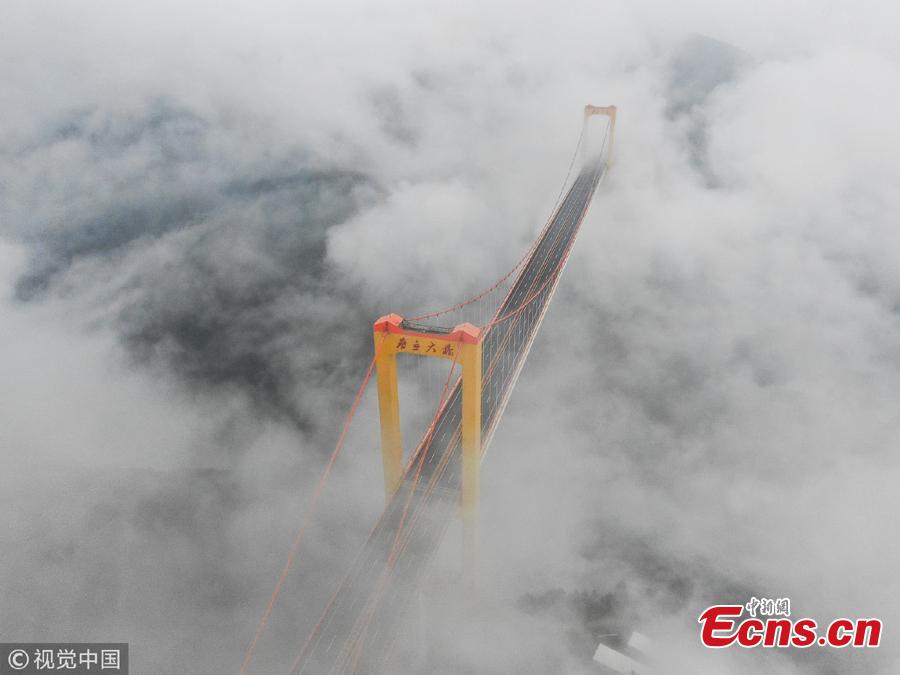 Clouds surround the Puli Bridge, which connects Guizhou and Yunnan provinces in southwest China. The bridge, one of the world\'s highest, stands hundreds of meters above the Beipan River and links Duge of Guizhou and Puli of Yunnna, attracting tourists with its stunning views. (Photo/VCG)