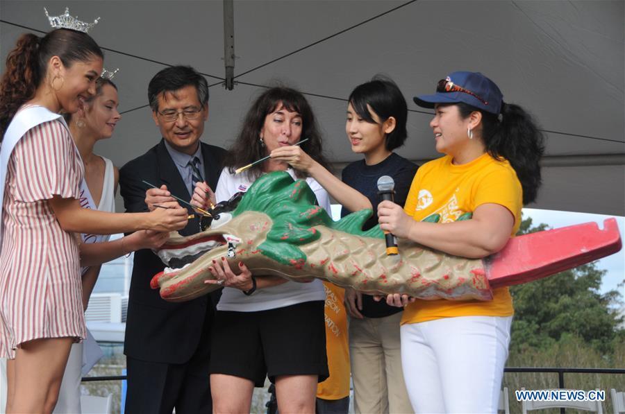 Xie Fei (3rd L), Chinese consul for cultural affairs in Houston, dots the eyes of a dragon with other guests during a dragon awakening ceremony in Houston, Texas, the United States, Oct. 13, 2018. The 15th annual Gulf Coast International Dragon Boat Regatta kicked off on Saturday in Sugar Land in Southwest Houston, Texas, the United States, aiming to promote the tradition and share this aspect of Asian culture. (Xinhua/Sun Jiayi)