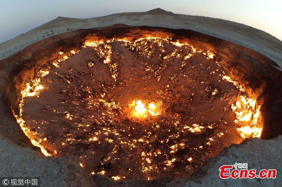 The \'Door to Hell,\' also known as the Crater of Fire, is a natural gas field in Derweze, Turkmenistan, that collapsed into an underground cavern in 1971, becoming a natural gas crater. Geologists set it on fire to prevent the spread of methane gas, and it has been burning continuously since then. The crater is a popular tourist attraction. (Photo/VCG)