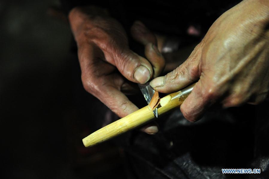 Craftsman Liang Zeguang whittles a sound hole on the tube of Lusheng at Jinying Village in Congjiang County of Miao and Dong Autonomous Prefecture of Qiandongnan, southwest China\'s Guizhou Province, on Oct. 16, 2018. Lusheng is an ethnic musical instrument with multiple bamboo pipes set into a wooden blowing tube. It is popular among the people of some ethnic groups living in southwestern China. Jinying Village, known for making Lusheng, still keeps the traditional Lusheng making techniques which include over 30 steps such as choosing material, installing reed and whittling sound hole. People often play the Lusheng while gathering to celebrate some major festivals. (Xinhua/Yang Wenbin)
