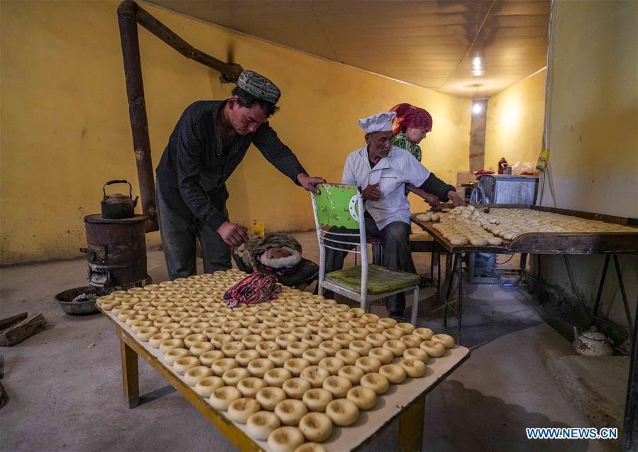 Yusup Tapuhan (C) makes butter naan at home in Yuli County of the Mongolian Autonomous Prefecture of Bayingolin, northwest China\'s Xinjiang Uygur Autonomous Region, Oct. 17, 2018. Yusup Tapuhan launched his butter naan business in 2000. The making of this popular pastry has been a tradition in Yuli County. In 2017, a dedicated local naan guild was established to help those in the business optimize profit. Yusup, who is 63, became one of the guild\'s earliest members. With the help of his family, Yusup can make 50 kilograms of butter naan and earn 500 yuan (72 U.S. dollars) a day. (Xinhua/Zhao Ge)