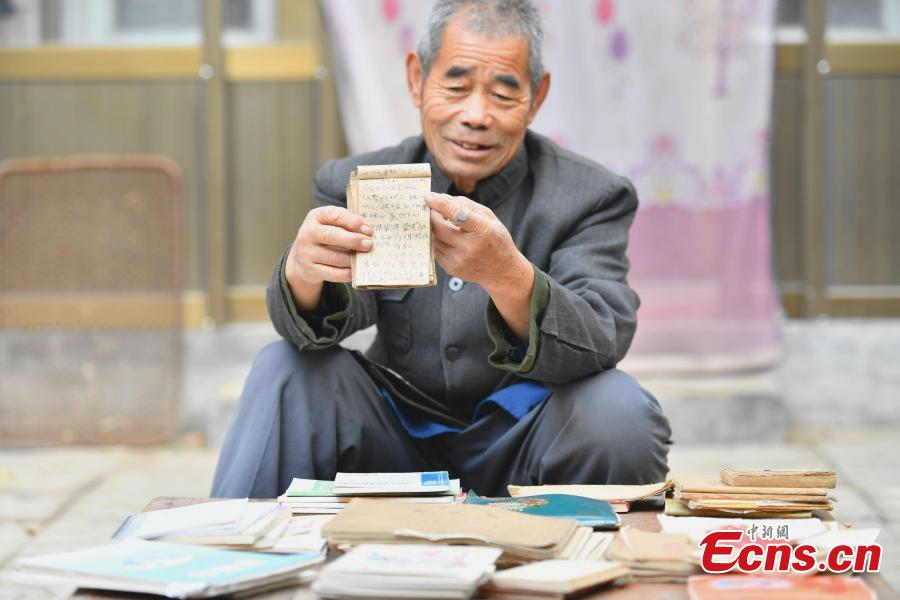 <?php echo strip_tags(addslashes(Farmer Jia Zengwen shows a diary he began to write 60 years ago at his home in Niujia Village, Gaocheng City, North China’s Hebei Province, Oct. 18, 2018. Jia has filled 108 diaries over the years, and they include records of his first time receiving the subsidy, a medical insurance claim, and the pension. The diaries also provide a record of the change that has taken place in his rural home over the past 40 years of reform and opening up. (Photo: China News Service/Zhai Yujia))) ?>