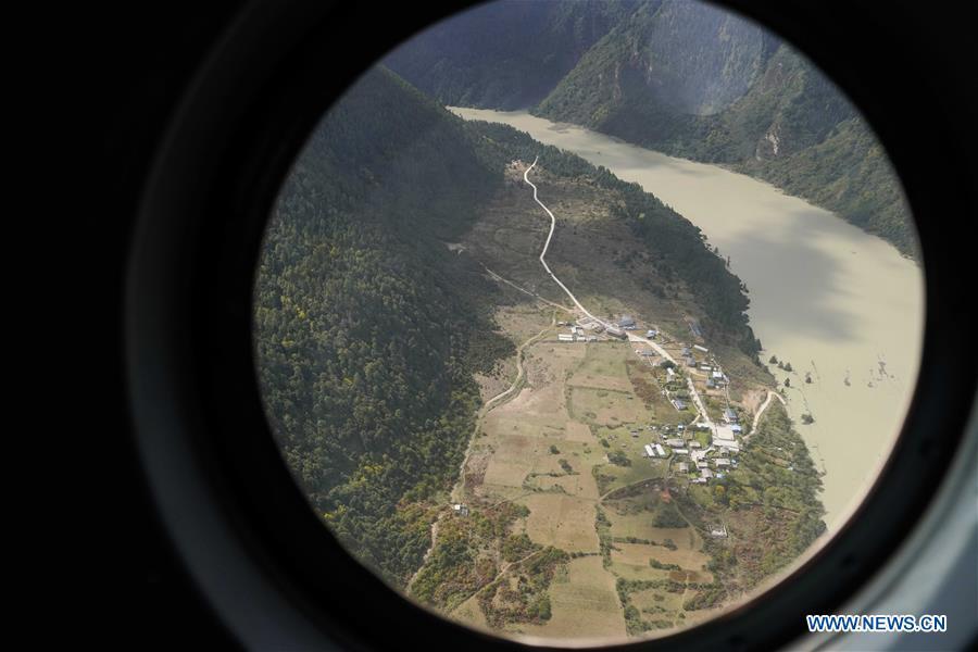 Aerial photo taken on Oct. 18, 2018 shows the Jiala Village threatened by the landslide-caused barrier lake on the Yarlung Tsangpo River in Menling County, southwest China\'s Tibet Autonomous Region. More than 6,000 people have been evacuated after a barrier lake formed following a landslide in the Yarlung Tsangpo River in southwest China\'s Tibet Autonomous Region, local authorities said Thursday. According to the local disaster relief headquarters, the landslide struck during the early hours of Wednesday near a village in Menling County, blocking the river\'s waterway. The amounts of water in the lake has surpassed 300 million cubic meters. No casualties have been reported. Authorities in Tibet have launched an emergency response, monitoring the lake\'s water level, evacuating local residents and sending relief supplies to the disaster-hit areas. (Xinhua/Purbu Zhaxi)