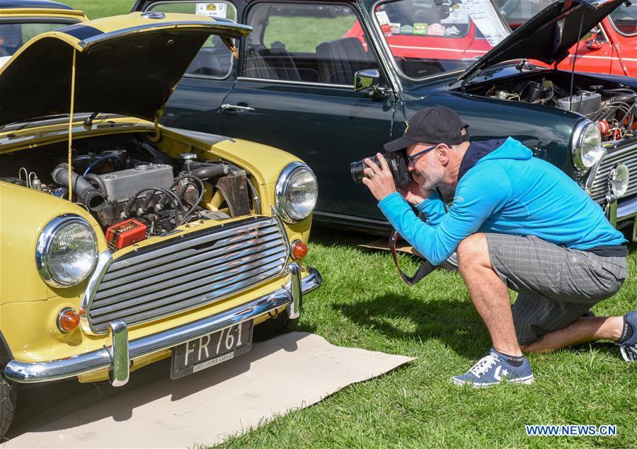 A man takes photos of a BMW MINI Cooper vehicle in Wellington, New Zealand, on Oct. 20, 2018. More than 120 BMW MINI Cooper vehicles are displayed during the 24th Mini Nationals Show and Shine. (Xinhua/Guo Lei)