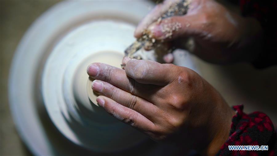 A craftsman named Jiang Peihua polishes the earthen body of an eggshell porcelain in Jingdezhen, east China\'s Jiangxi Province, on Oct. 19, 2018. Eggshell porcelain, one of the traditional porcelains produced in \