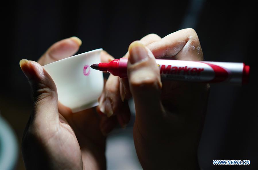 <?php echo strip_tags(addslashes(A craftsman named Wang Minhui makes a mark on the body of an unqualified finished eggshell porcelain in Jingdezhen, east China's Jiangxi Province, on Oct. 19, 2018. Eggshell porcelain, one of the traditional porcelains produced in 