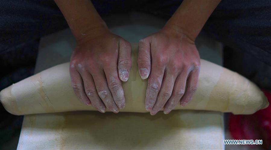 A craftsman named Jiang Xinteng kneads mud for making eggshell porcelain in Jingdezhen, east China\'s Jiangxi Province, on Oct. 19, 2018. Eggshell porcelain, one of the traditional porcelains produced in \