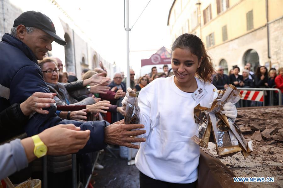 A staff member distributes chocolate chunks to visitors during the 25th international chocolate festival \