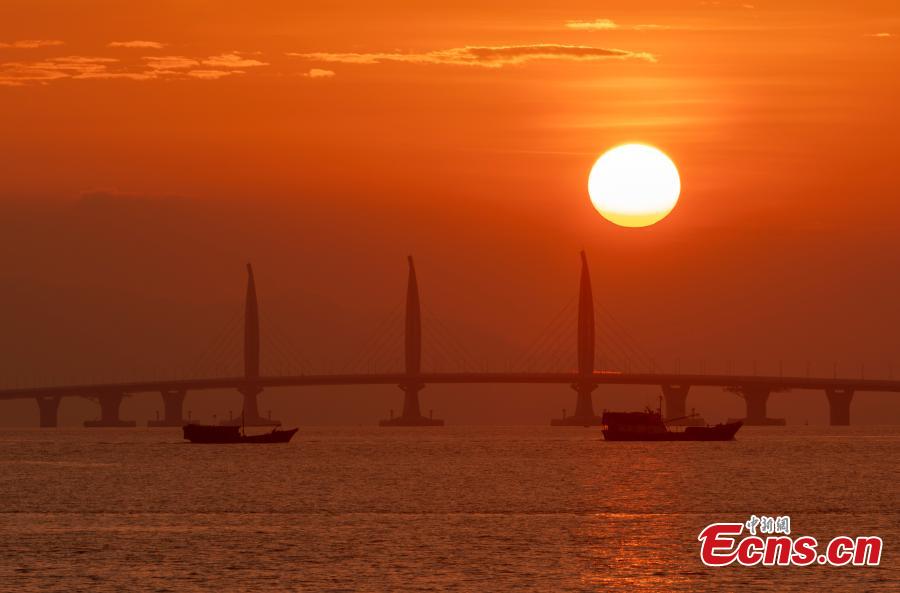 A view of the Hong Kong-Zhuhai-Macao Bridge at sunrise from Qinglv Road in Zhuhai City, South China’s Guangdong Province, Oct. 22, 2018. The world\'s longest sea bridge will start operation on Oct. 24, further integrating cities in the Pearl River Delta. (Photo: China News Service/Zhang Wei)