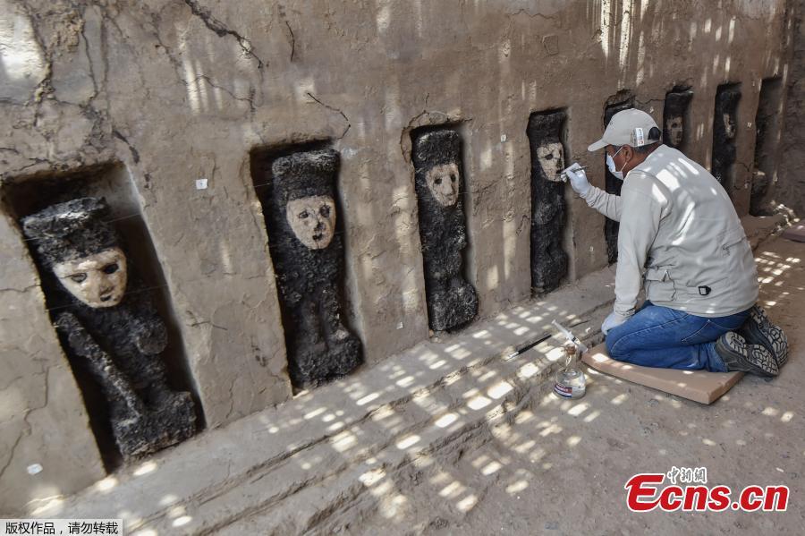 An archaeologist cleans a mural of the Mochica culture at Chan Chan archeological complex in Trujillo, Peru, Oct. 22, 2018. Archeologists in Peru have found 20 800-year-old wooden statues in the largest pre-Columbian site in the Americas, Culture Minister, Patricia Balbuena and researchers revealed on Monday. (Photo/Agencies)