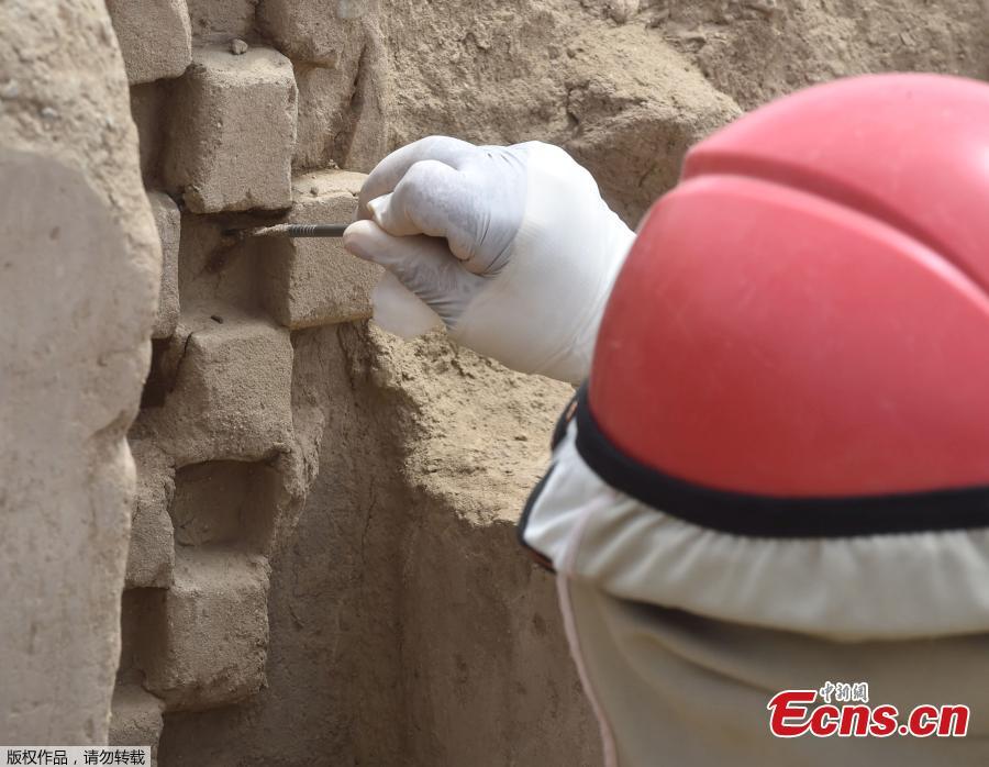 An archaeologist cleans a mural of the Mochica culture at Chan Chan archeological complex in Trujillo, Peru, Oct. 22, 2018. Archeologists in Peru have found 20 800-year-old wooden statues in the largest pre-Columbian site in the Americas, Culture Minister, Patricia Balbuena and researchers revealed on Monday. (Photo/Agencies)