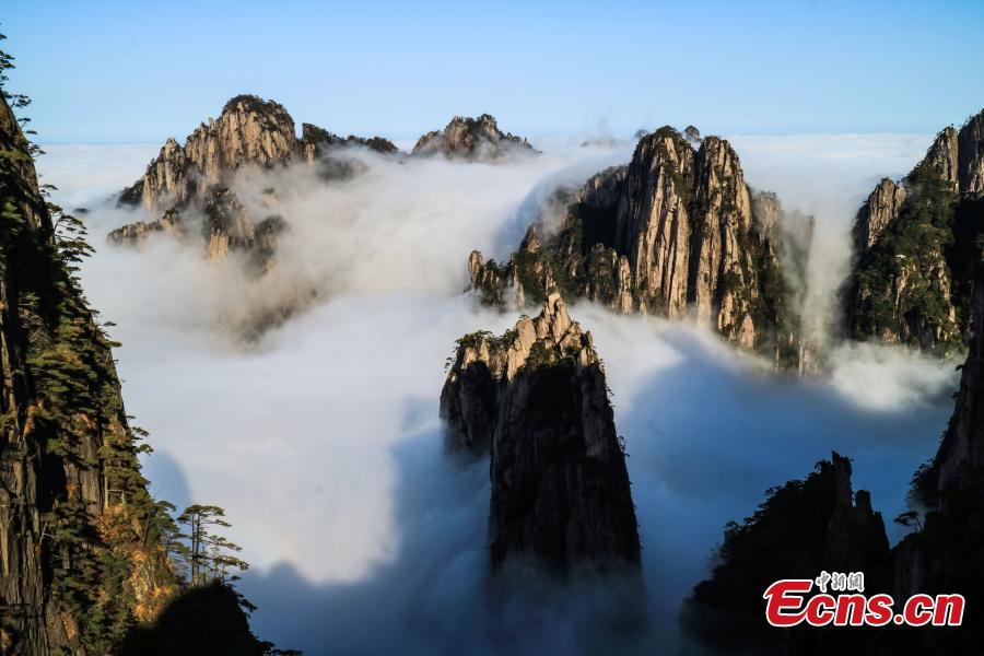 Mist and clouds surround Mount Huangshan in Anhui Province on Oct. 23, 2018. A UNESCO World Heritage site, the area is well known for its scenery, sunsets, peculiarly-shaped granite peaks, and Huangshan pine trees. (Photo: China News Service/Li Jingang)