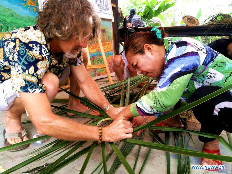 <?php echo strip_tags(addslashes(Canadian Craig Anderson (L) teaches a local resident to make artwork on the West Island in Sanya, south China's Hainan Province, April 8, 2018. Anderson arrived in February at the West Island inhabited by around 4,000 people. Locals regarded Anderson as a scavenger when he first arrived, as he wandered around the beach almost every day, picking up driftwood, plastic bottles, shattered glasses, and rusty pieces of iron. As time went by, the locals realized that Anderson is an artist who devotes himself in environment protection art design. He profits the recyclable and regenerative materials in making art works. (Xinhua/Yang Guanyu))) ?>
