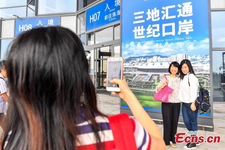 Passengers pose for a photo at the Zhuhai Port of the Hong Kong-Zhuhai-Macao Bridge, Octo. 24, 2018. (Photo: China News Service/ Chen Jimin)