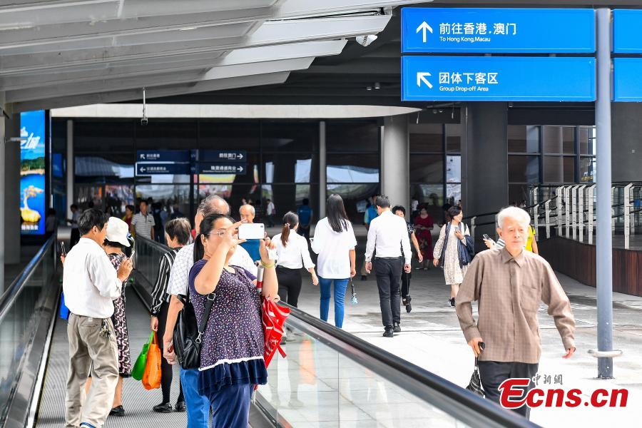 Passengers pose for a photo at the Zhuhai Port of the Hong Kong-Zhuhai-Macao Bridge, Octo. 24, 2018. (Photo: China News Service/ Chen Jimin)