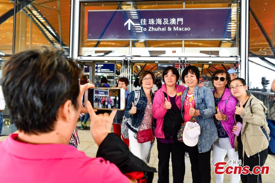 Passengers pose for a photo at the Zhuhai Port of the Hong Kong-Zhuhai-Macao Bridge, Octo. 24, 2018. (Photo: China News Service/ Chen Jimin)