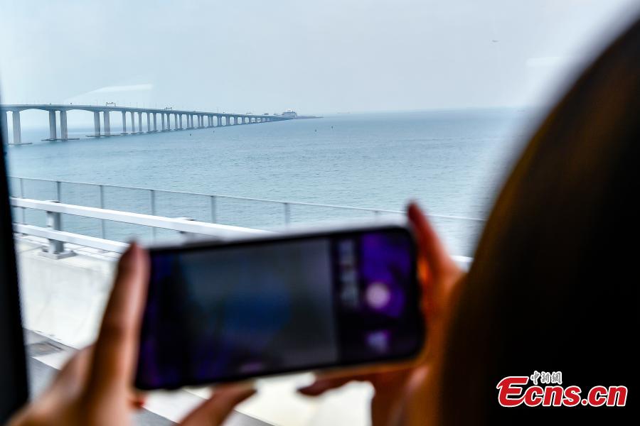 A passenger inside a coach takes a photo of the Zhuhai-Hong Kong-Macao Bridge Oct. 24, 2018. (Photo: China News Service/Chen Jimin)