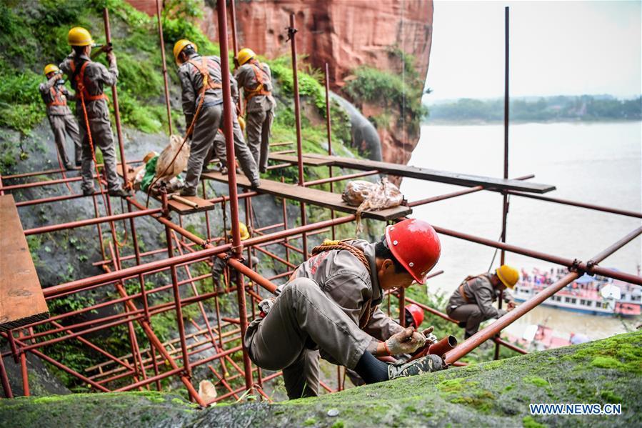 Workers install scaffolds for the examination work of the Leshan Giant Buddha in Leshan City, southwest China\'s Sichuan Province, Oct. 19, 2018. The examination of Leshan Giant Buddha started on Oct. 8 to collect data for better restoration. (Xinhua/Zhang Chaoqun)