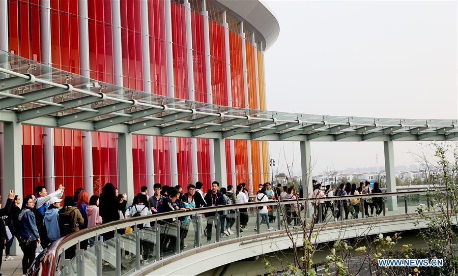 Volunteers for the upcoming China International Import Expo (CIIE) are seen outside the National Exhibition and Convention Center in Shanghai, east China, Oct. 26, 2018. The exhibition booth arrangement work for the CIIE has begun in Shanghai, the organizer said Thursday. Over 1,800 exhibition booths will be set up by the end of the month, before exhibitors start to display products on Nov. 1 and 2, according to the China International Import Expo Bureau. (Xinhua/Fang Zhe)