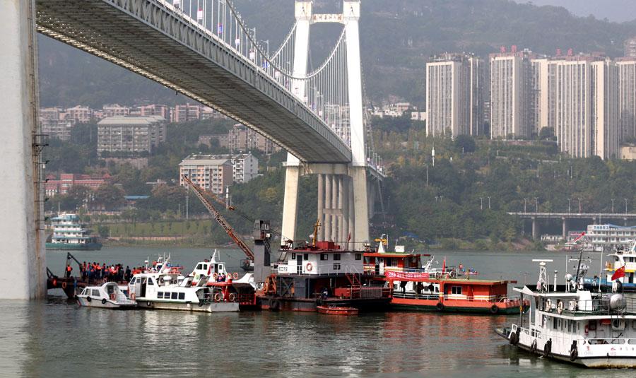 Search and rescue efforts continue after a deadly collision between a bus and a private car on Sunday. The bus careened off a bridge in Chongqing into the Yangtze River. (Photo by ZOU YI/FOR CHINA DAILY)

Authorities say more than 10 were on board; 2 bodies are recovered

At least two people died after a bus collided with an oncoming car on a Chongqing bridge and plunged into the Yangtze River on Sunday morning.

Based on inquires and footage from surveillance cameras along the route, it was estimated that the bus was carrying more than 10 passengers at the time of the crash, local authorities said in a statement.

Two bodies had been recovered from the water as of press time.

An initial investigation found that the bus abruptly swerved while on the Second Yangtze River Bridge in Chongqing\'s Wanzhou district, crossing the center of the road into oncoming traffic and slamming into a red sedan.

The bus then broke through the guardrail and plunged into the river.