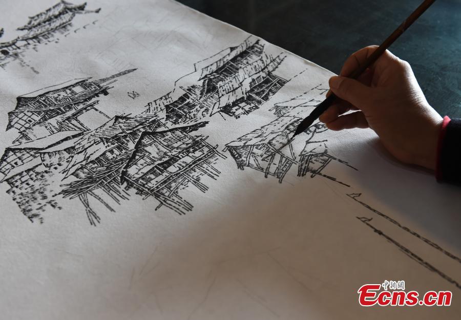 Qin Tingguang, in his seventies, shows his paintings drawn with ink brushes in his home in Southwest China’s Chongqing Municipality, Oct. 29, 2018. Based on his memory, Qin has spent five years drawing 44 paintings of the city’s landmarks 20 years ago. (Photo: China News Service/Zhou Yi)