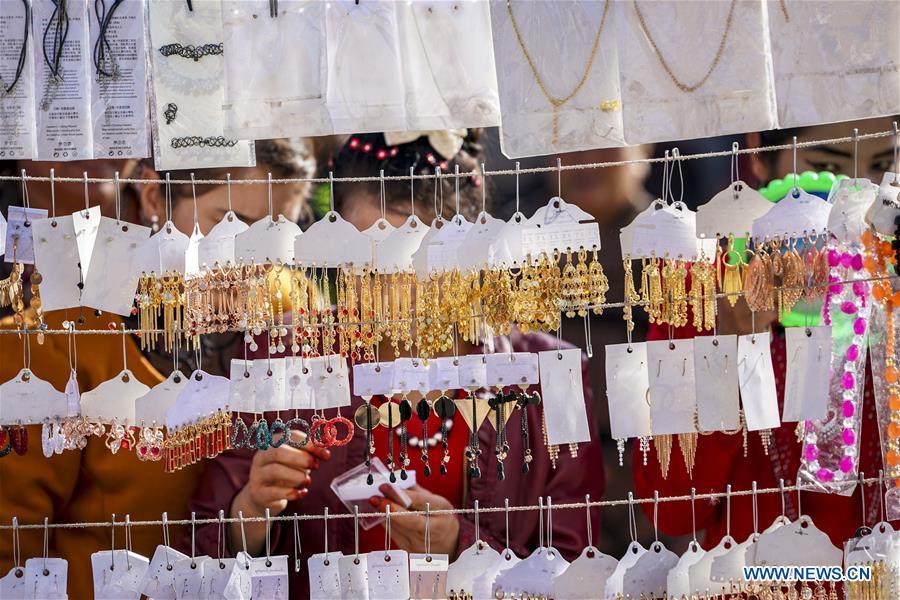 People select earrings at a Sunday bazaar in Bachu County, northwest China\'s Xinjiang Uygur Autonomous Region, Oct. 28, 2018. (Xinhua/Hu Huhu)
