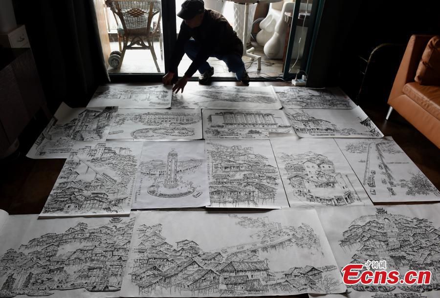 Qin Tingguang, in his seventies, shows his paintings drawn with ink brushes in his home in Southwest China’s Chongqing Municipality, Oct. 29, 2018. Based on his memory, Qin has spent five years drawing 44 paintings of the city’s landmarks 20 years ago. (Photo: China News Service/Zhou Yi)