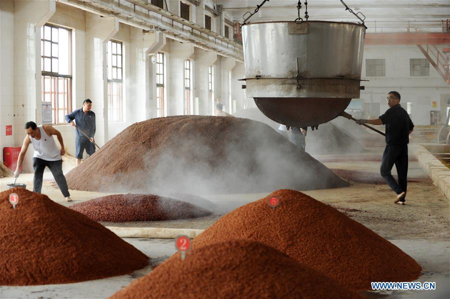 Workers process sorghum grains at a distillery of Kweichow Moutai in Maotai town in the city of Renhuai in southwest China\'s Guizhou Province, Oct. 23, 2018. Maotai is a small town in Renhuai City in mountainous Guizhou. What distinguishes it from other Chinese small towns is that it produces a famous brand of Chinese liquor Moutai, which often served on official occasions and at state banquets. The spirit, made from sorghum and wheat, takes up to five years for the whole production process, involving nine times of steaming, eight times of fermentation and seven times of distillation, before aged in clay pots. Moutai is also considered a luxury item that has long been a popular gift. China\'s alcohol industry earned about 1 trillion yuan in revenue in 2017. The total profits rose by 36 percent year on year to over 100 billion yuan, according to China National Light Industry Council. (Xinhua/Yang Wenbin)