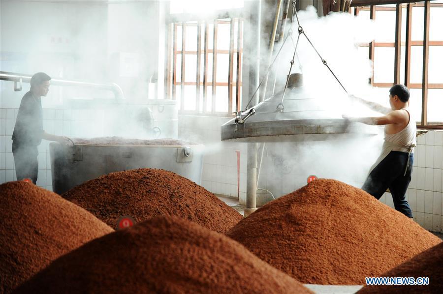 Workers process sorghum grains at a distillery in Maotai town in the city of Renhuai in southwest China\'s Guizhou Province, Oct. 23, 2018. Maotai is a small town in Renhuai City in mountainous Guizhou. What distinguishes it from other Chinese small towns is that it produces a famous brand of Chinese liquor Moutai, which often served on official occasions and at state banquets. The spirit, made from sorghum and wheat, takes up to five years for the whole production process, involving nine times of steaming, eight times of fermentation and seven times of distillation, before aged in clay pots. Moutai is also considered a luxury item that has long been a popular gift. China\'s alcohol industry earned about 1 trillion yuan in revenue in 2017. The total profits rose by 36 percent year on year to over 100 billion yuan, according to China National Light Industry Council. (Xinhua/Yang Wenbin)