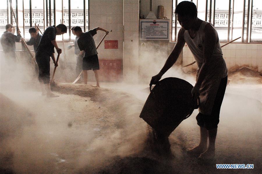 Workers process sorghum grains at a distillery of Kweichow Moutai in Maotai town in the city of Renhuai in southwest China\'s Guizhou Province, Oct. 23, 2018. Maotai is a small town in Renhuai City in mountainous Guizhou. What distinguishes it from other Chinese small towns is that it produces a famous brand of Chinese liquor Moutai, which often served on official occasions and at state banquets. The spirit, made from sorghum and wheat, takes up to five years for the whole production process, involving nine times of steaming, eight times of fermentation and seven times of distillation, before aged in clay pots. Moutai is also considered a luxury item that has long been a popular gift. China\'s alcohol industry earned about 1 trillion yuan in revenue in 2017. The total profits rose by 36 percent year on year to over 100 billion yuan, according to China National Light Industry Council. (Xinhua/Lin Liping)