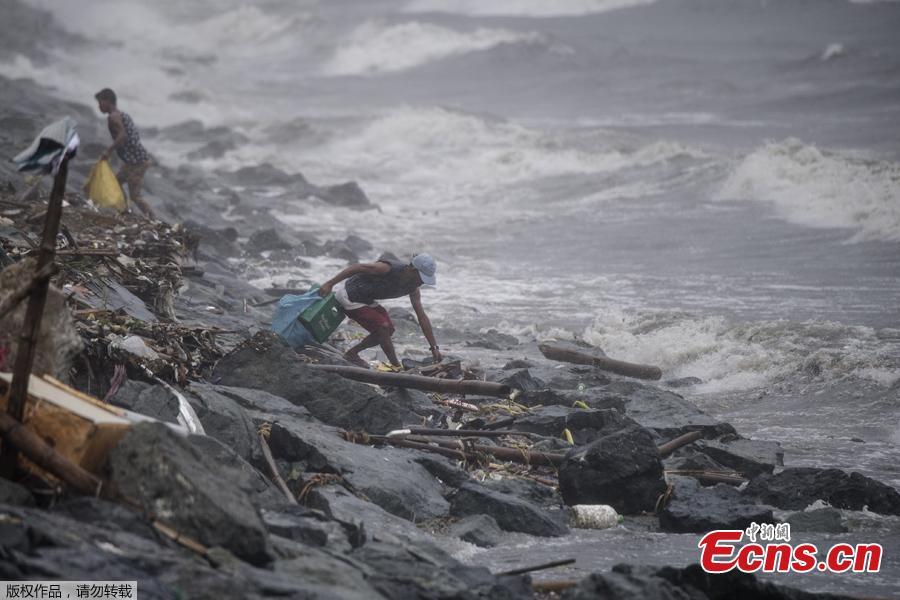 A scavenger collects recyclable materials along the breakwater amid strong waves as weather patterns from Typhoon Yutu affect Manila Bay on Oct. 30, 2018. Typhoon Yutu slammed into the Philippines on Tuesday with fierce winds that sheared off roofs and snapped trees in half, after thousands were evacuated ahead of the powerful storm\'s arrival. (Photo/Agencies)