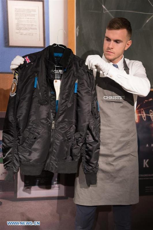 A staff member of auctioneer Christie\'s shows a bomber jacket worn by Stephen Hawking during a photocall for an online auction in London, Britain, on Oct. 30, 2018. An online sale of 22 items from the late physicist Stephen Hawking by auctioneer Christie\'s will open for bids on Oct. 31. The auction will include some of Hawking\'s complex scientific papers, one of his iconic wheelchairs and a script from the famous TV comedy show \